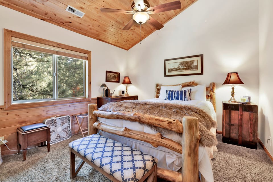 Peaceful cabin bedroom with plush bedding, and beautiful views—ideal for restful nights, cozy mornings, and a relaxing mountain escape.