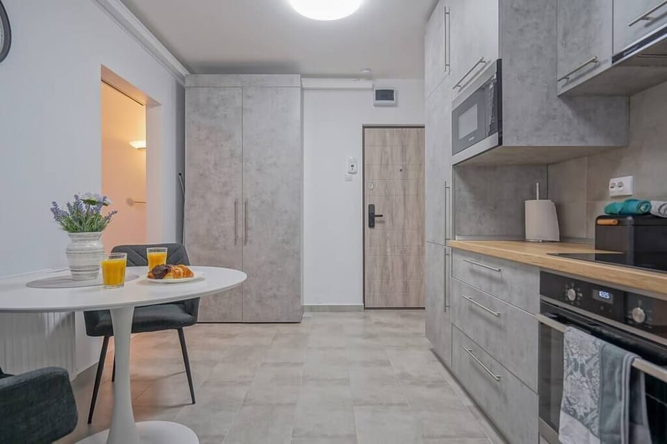 Fully equipped kitchen with fridge, freezer, oven, stove, coffee espresso machine, toaster, water kettle, microwave, cooking utensils, cooking basics and dining table.