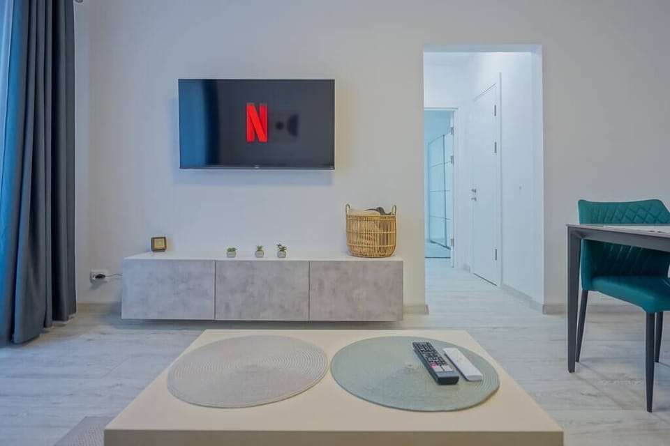 Living room with extendable sofa, smart TV with Netflix, access to the terrace with panoramic mountain view, extra pillows and blankets and dining table.