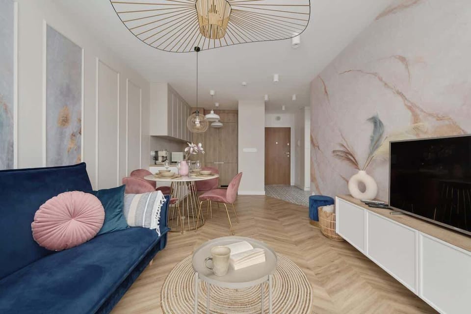 A stylish living area with a modern TV unit, a large window with curtains, and a cozy sofa.