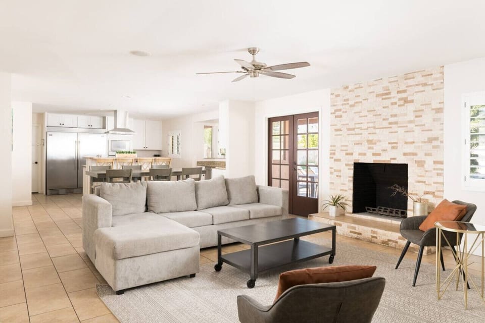 Relax in a spacious living area styled with a modern gray, white, and wooden color palette.