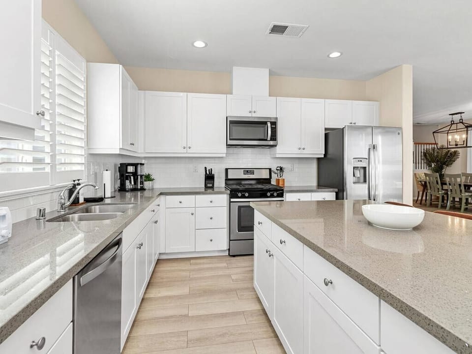 White, wooden cabinetry with stainless steel appliances