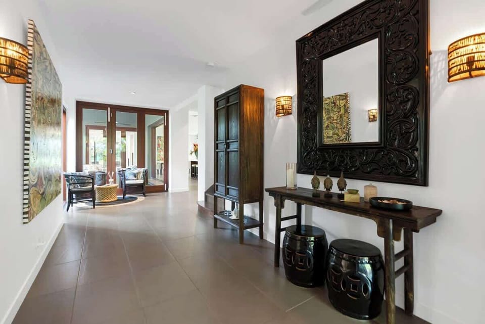 A seating nook at the entrance invites you to pause and enjoy the elegant blend of textures and tropical-inspired decor.