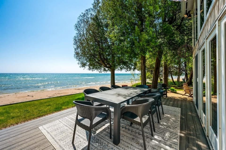 Step outside from the main living room onto this inviting deck, where outdoor dining meets the tranquil beauty of Lake Michigan.