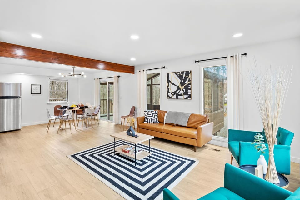 This airy layout seamlessly connects the living and dining areas, with contemporary furnishings, warm wood flooring, and a bright, inviting atmosphere.