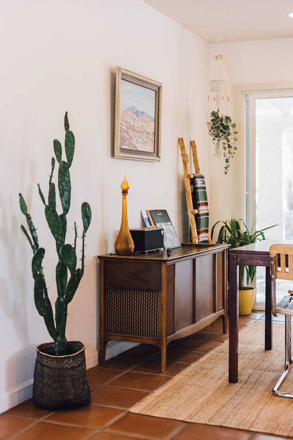 Add a touch of desert charm to your stay with this stylish and eclectic living room. The vintage furniture, artwork, and plants create a unique and inviting atmosphere.
