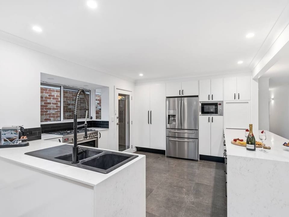 Modern gourmet kitchen with stone benchtops, Nespresso machine.