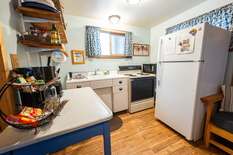 The kitchen has a refrigerator, electric range, microwave, coffee maker, toaster