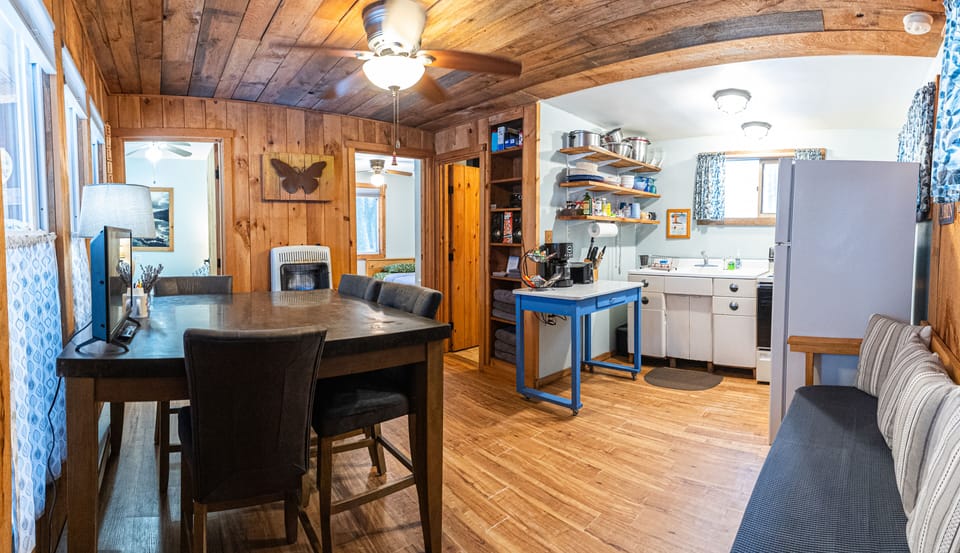 The main room of the cabin contains a couch, table and chairs and kitchen.