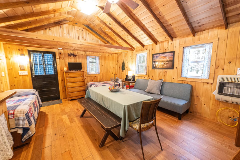 Main room contains a sofa, table and benches, a twin bed and a single cot