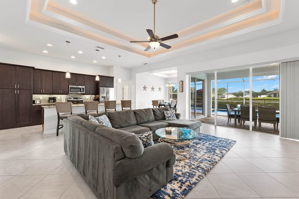 Stylish Gathering - - Spacious living area offering seamless access to the kitchen and outdoor views
- Cozy sectional and modern design create a comfy yet elegant vibe for entertaining
- Large sliding doors open to the lanai, blending indoor and outdoor living perfectly