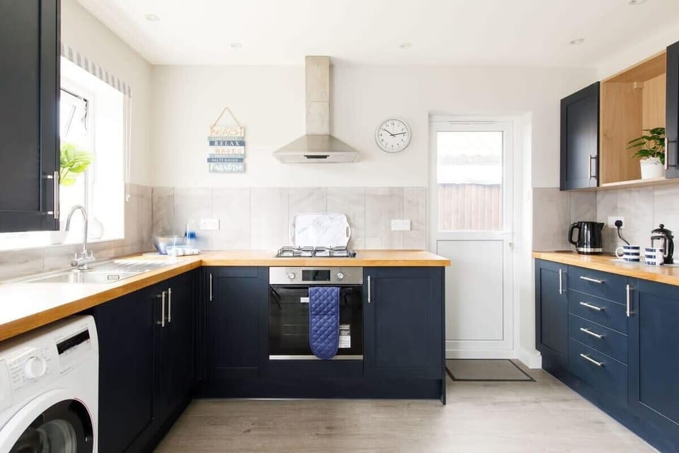 The fully-equipped kitchen, with dark blue cabinetry, has all the modern appliances you need for preparing meals and beach picnics.