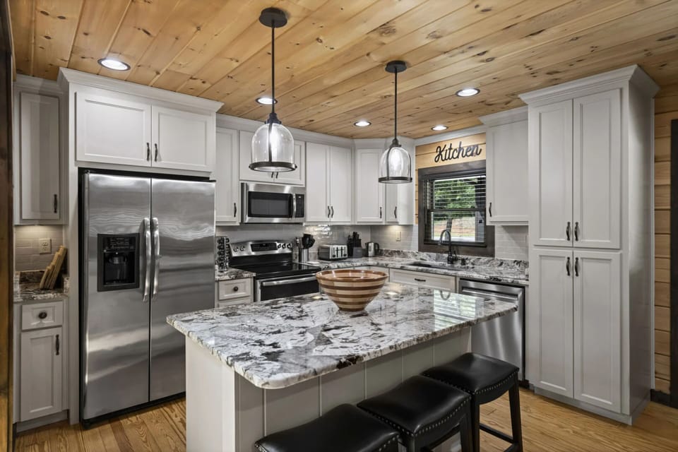 Fully stocked kitchen with center island table and barstool seating.