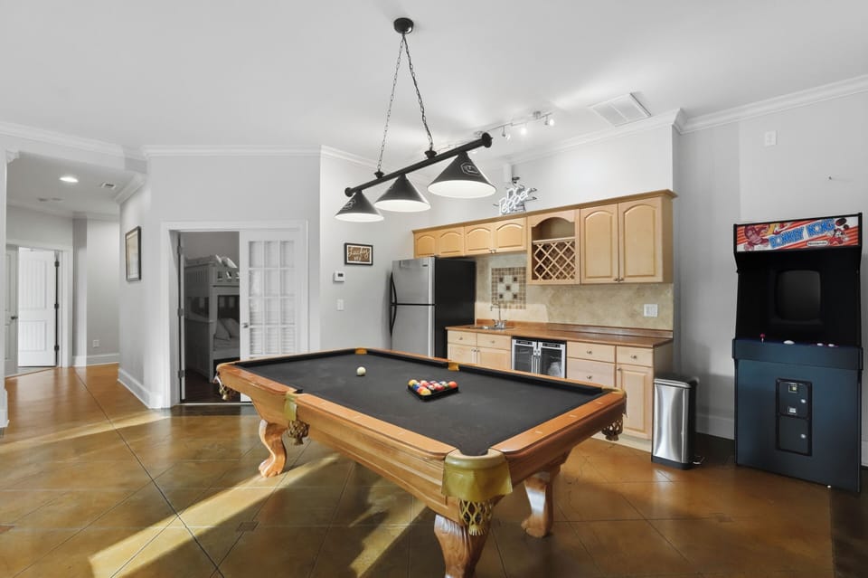 Game-ready rec room with a pool table, arcade, and kitchenette for easy group hangouts.