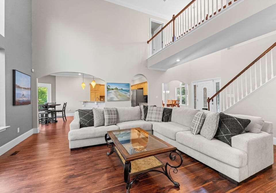 Living room with vaulted ceiling, comfy sectional and TV.