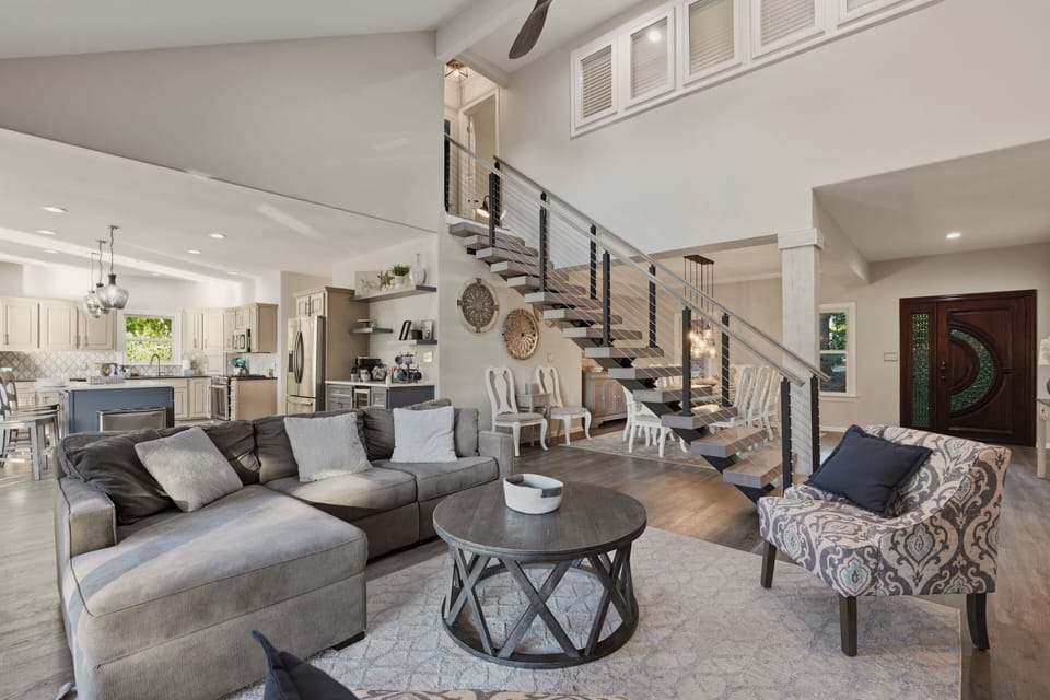 Open-concept living area with plush seating, soaring ceilings, and seamless flow to the kitchen and dining spaces.