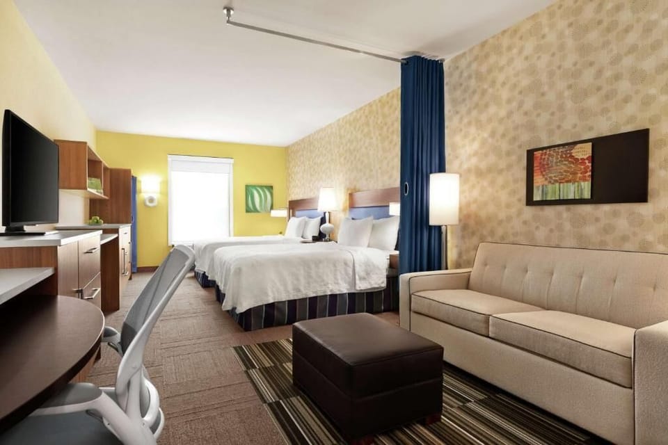 Relax together in a roomy double-queen suite with sofa seating.