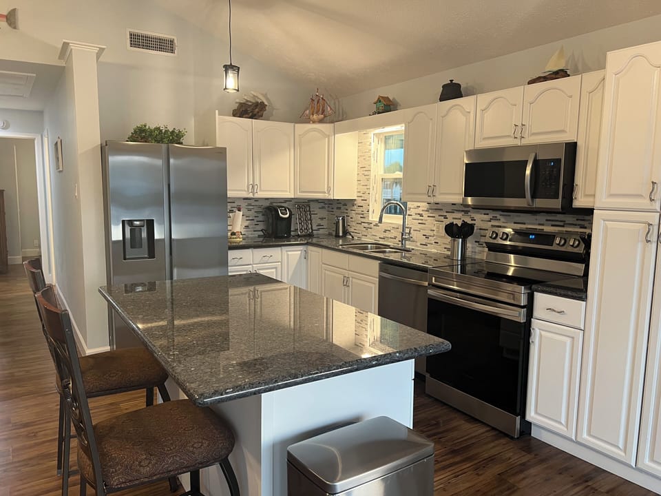 Large kitchen with a new stainless appliance.