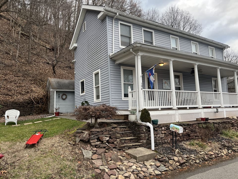 Front of house, parking to left for two cars