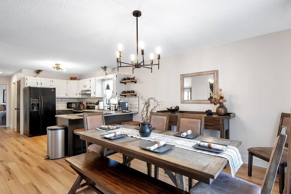 Dining room with large dining table, bar seating and buffet, opens to full kitchen.