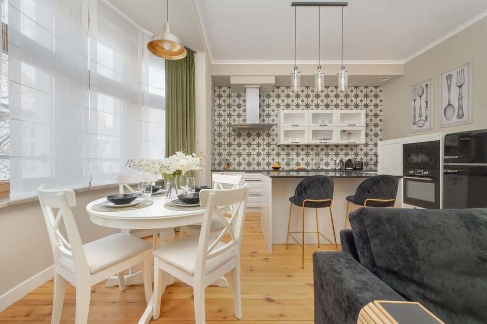 A spacious open-plan living area with a sofa, a dining table, and a kitchenette.