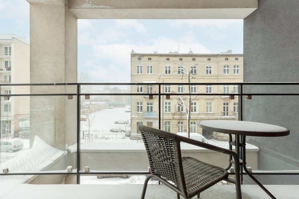 A balcony with a glass railing, offering a nice view of the surrounding area.