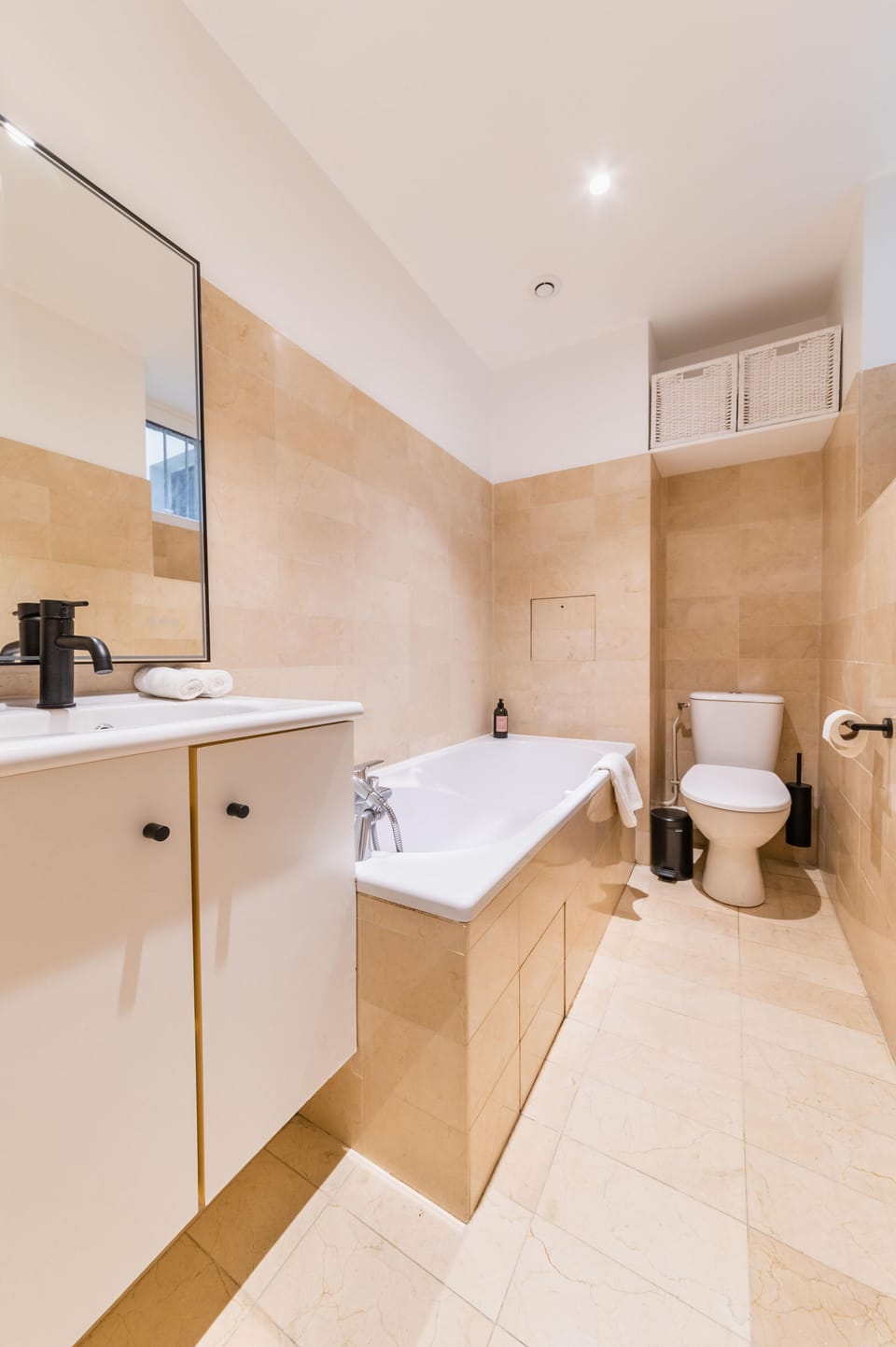A travertine bathroom with its large bathtub to relax from Parisian life...