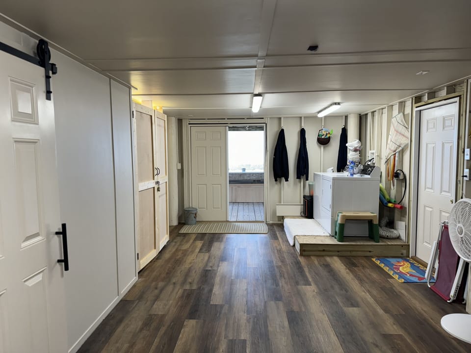 Bunk room behind barn door. Laundry, bathroom door, & tiki entrance on left.