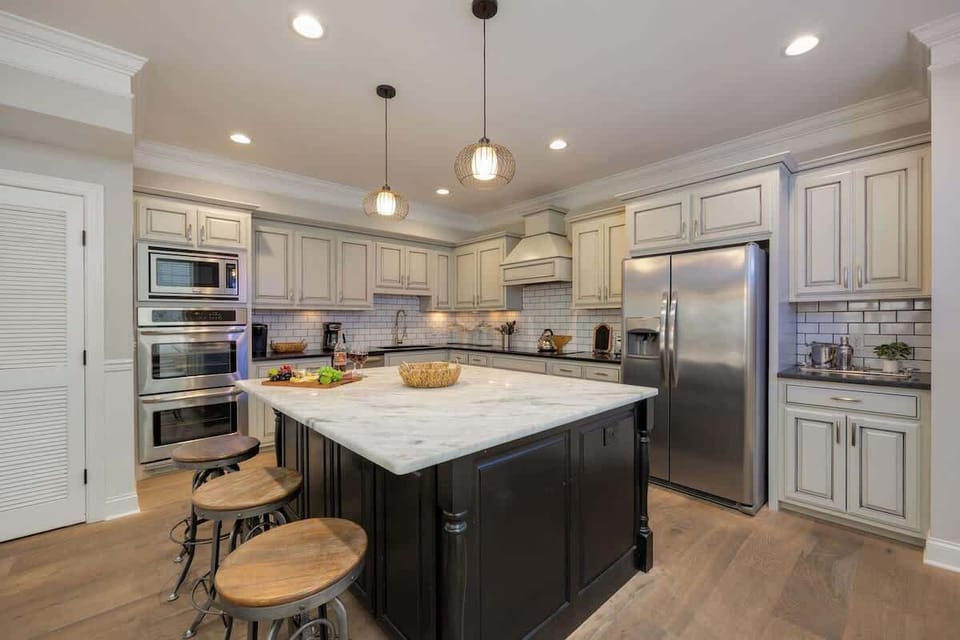 2nd Floor: Fully-equipped kitchen with stainless steel appliances, basic cooking essentials, a large island with bar seating, and wet bar.
