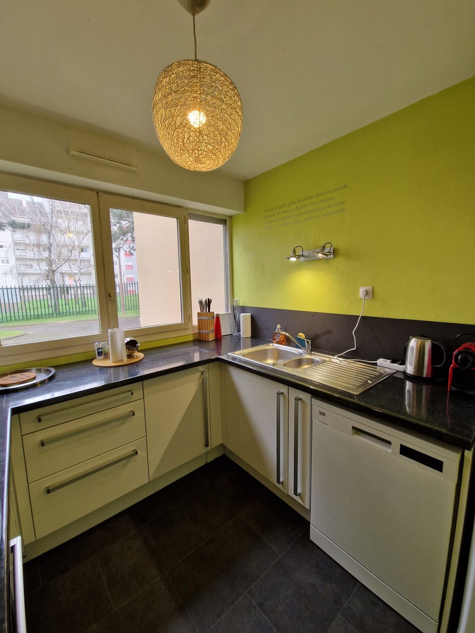 "Discover the chartreuse-yellow kitchen at the Le Square property in Le Mans through this photo. The kitchen is fully equipped and fitted, including a dishwasher for added convenience. The windows bring a beautiful luminosity to the space. Enjoy a charming and functional environment to prepare delicious meals during your stay."