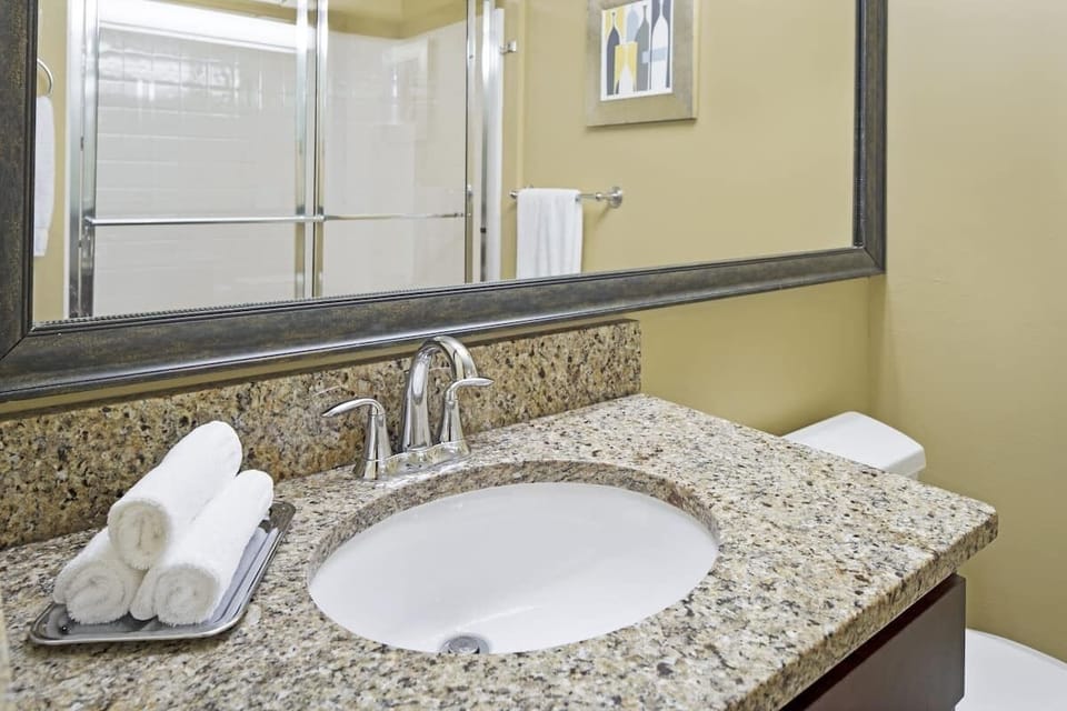 Refresh at a spotless granite vanity with fluffy rolled towels.
