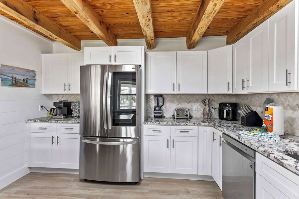 Clean, modern kitchen w/ stainless appliances & crisp white cabinetry.

