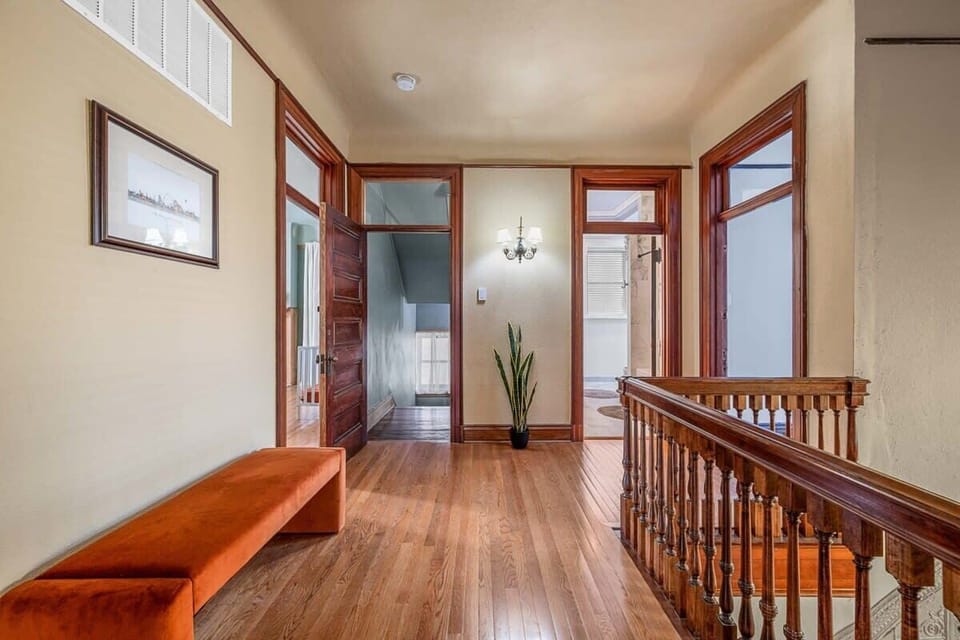 Experience the warmth and sophistication of this enchanting hallway, where the natural beauty of wood floors meets the elegance of a handcrafted wooden banister. #WarmthAndSophistication #NaturalBeauty #HandcraftedElegance 