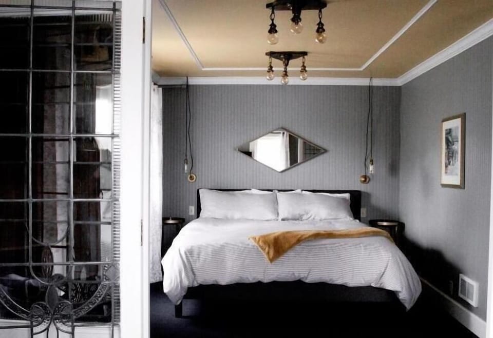 Settle into a serene bed beneath warm, glowing pendants.