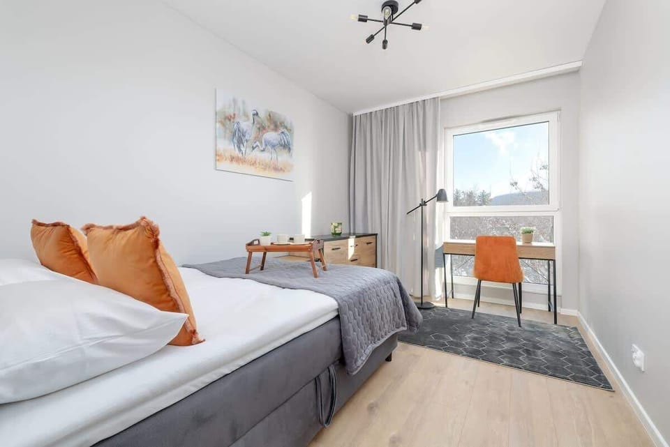 A comfortable bedroom with a double bed, bedside tables, and a wall painting.