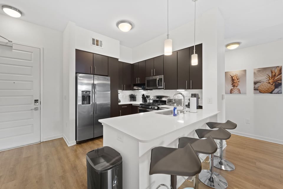 A modern kitchen featuring a two-door refrigerator and a side bar table.