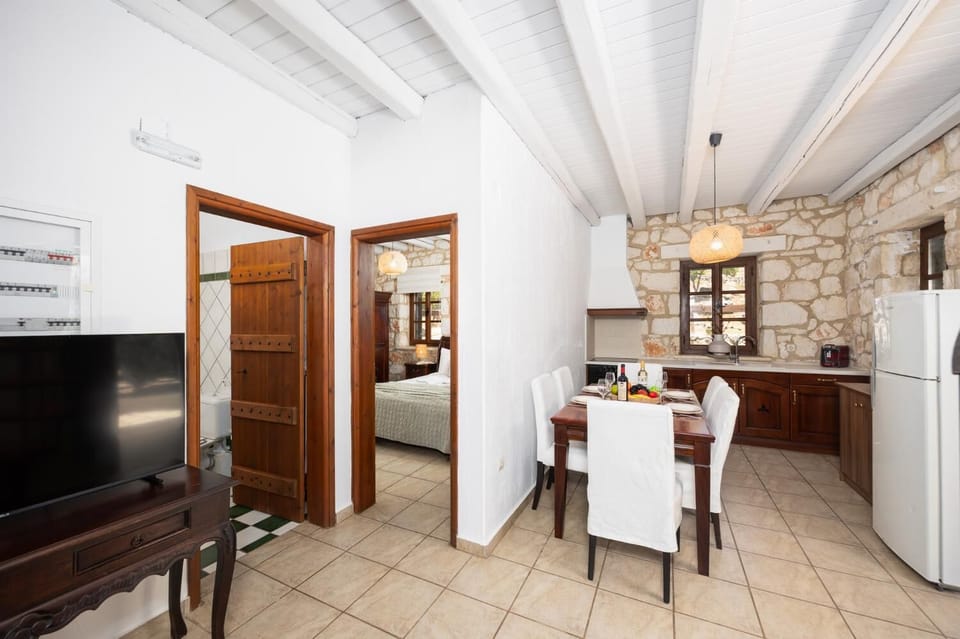 Open-plan living room with sofa, dining area, kitchen, ornamental fireplace, WiFi internet, and satellite TV