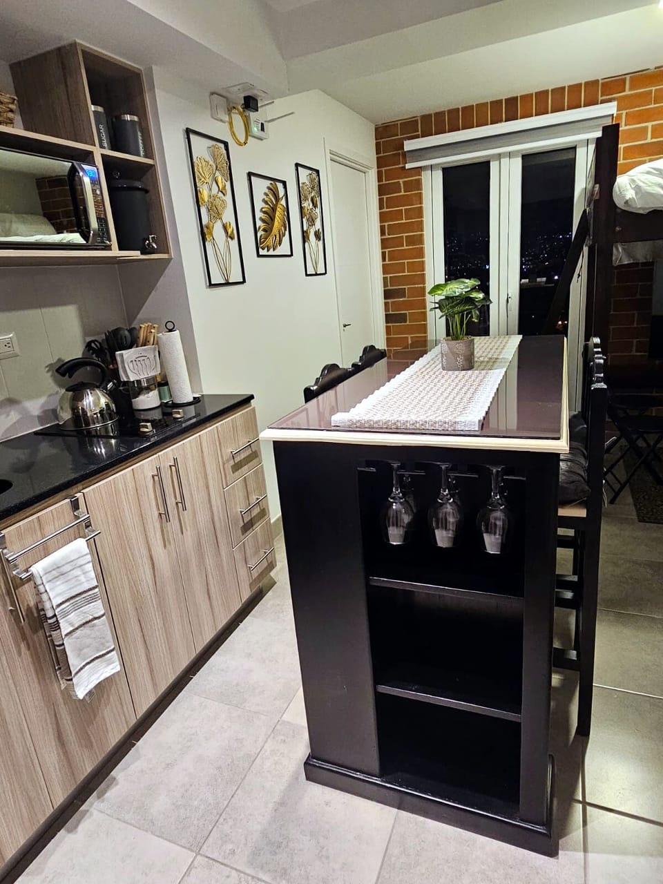 Comedor con copas y cocina equipada.