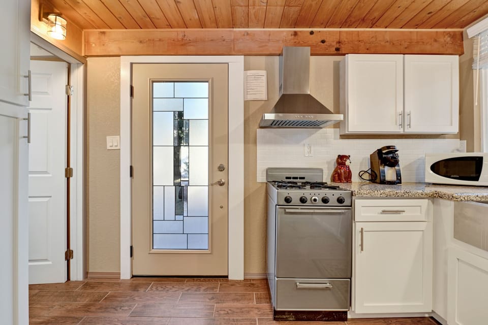 Fully equipped cabin kitchen with ample cabinetry, stove, fridge, microwave, and coffee maker—perfect for cooking meals, morning coffee, and feeling right at home on your stay.