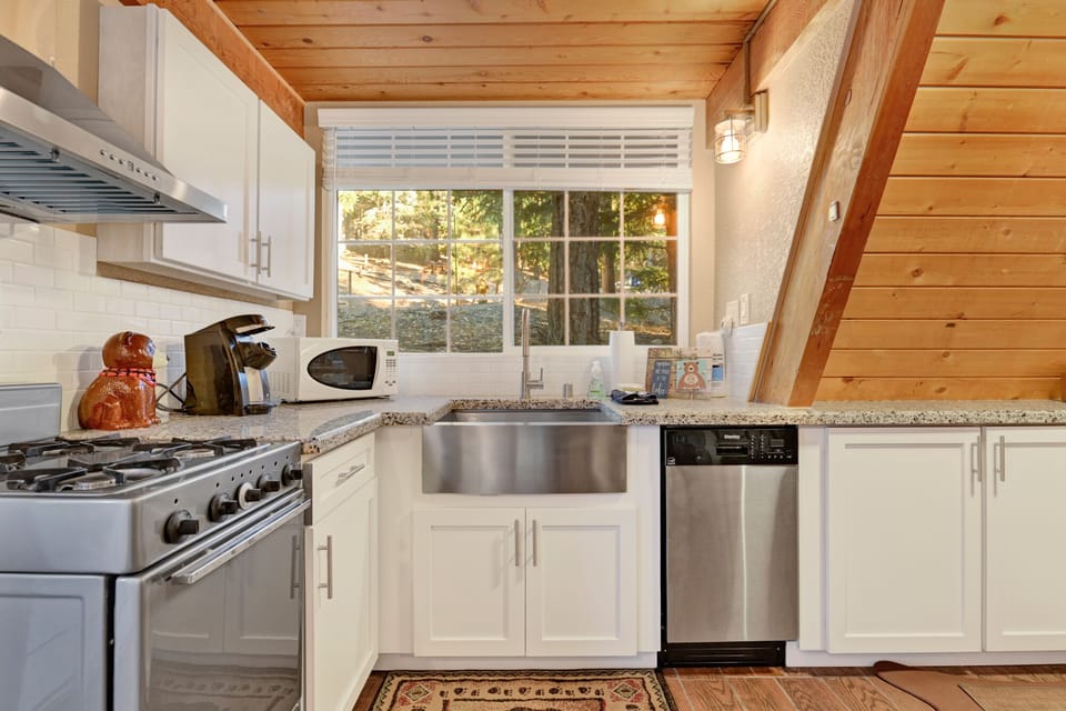 Fully equipped cabin kitchen with ample cabinetry, stove, fridge, microwave, and coffee maker—perfect for cooking meals, morning coffee, and feeling right at home on your stay.
