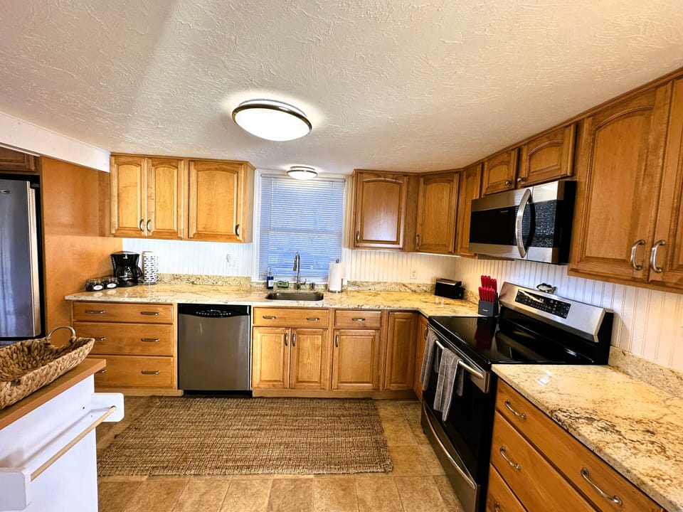 Full kitchen, dishwasher, induction range, and large stainless steel refrigerator