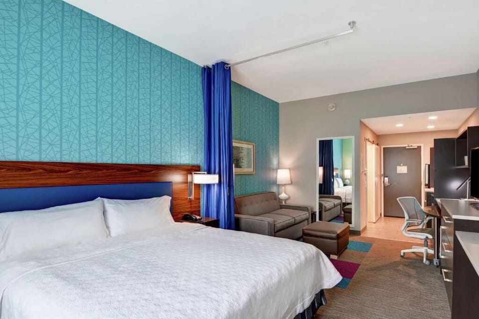 Relax in a cozy lounge area beside a beautifully made bed.