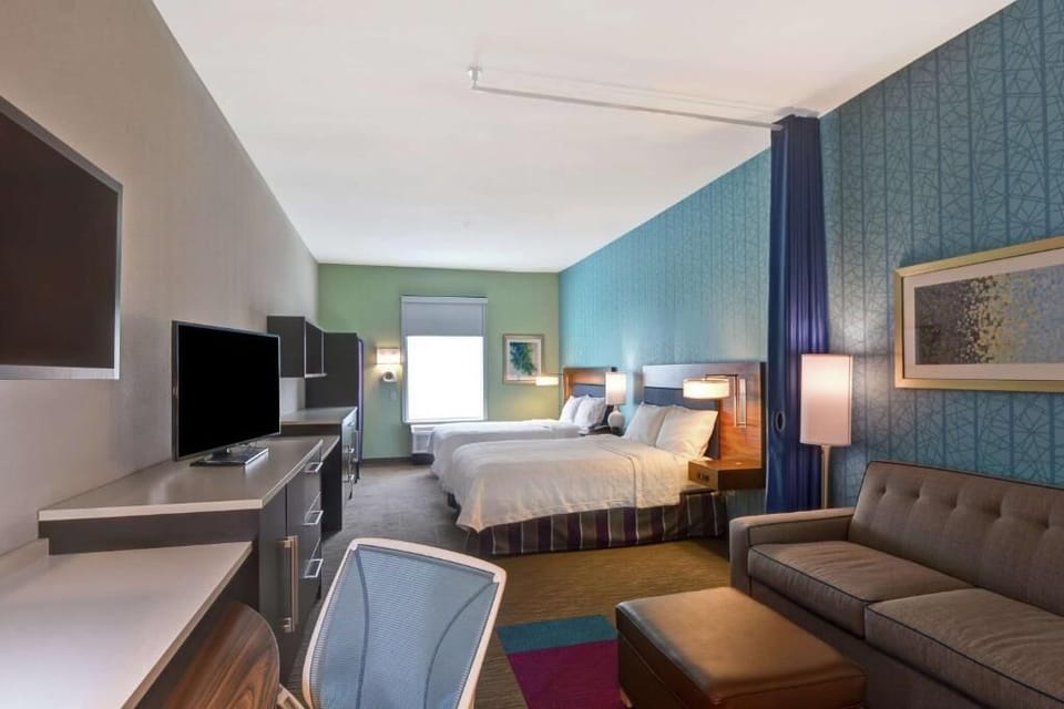 Settle into a bright suite with beds, lounge, and workspace.