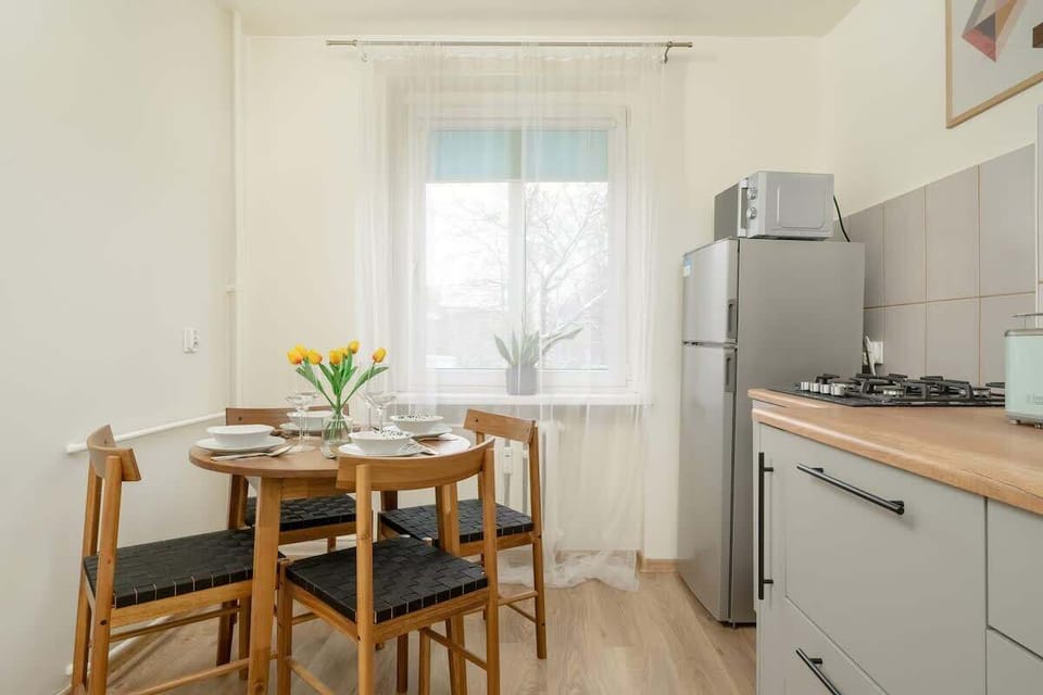 A stylish kitchen with white cabinets, a wooden countertop, and a dining table.