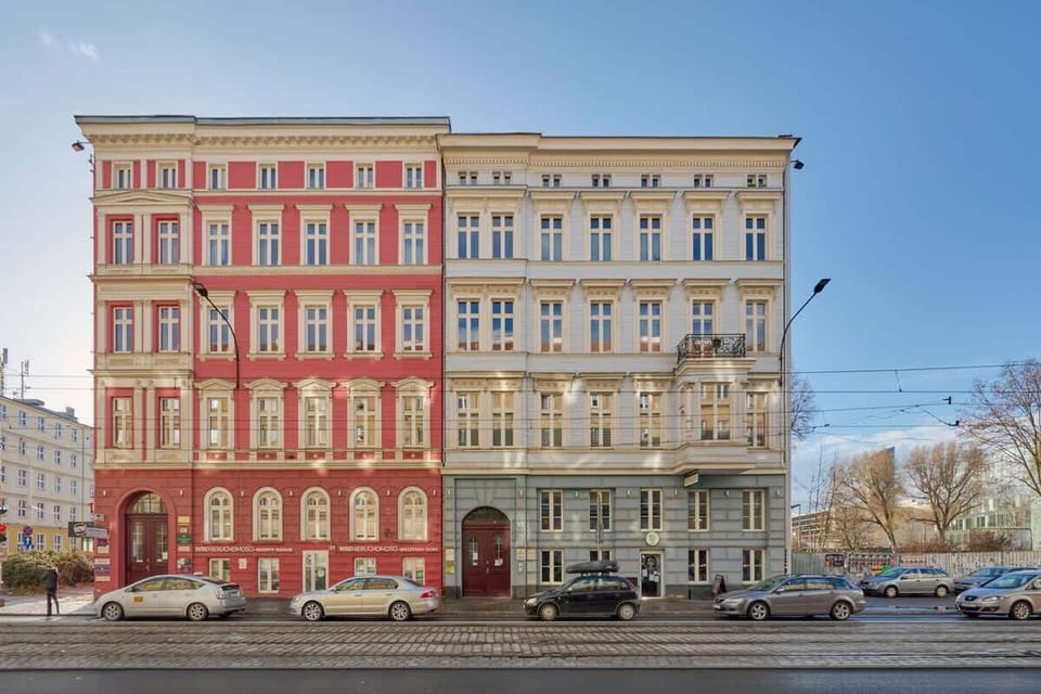 The colorful facade of a historic building with intricate architectural details, located in an urban area with a busy street view.
