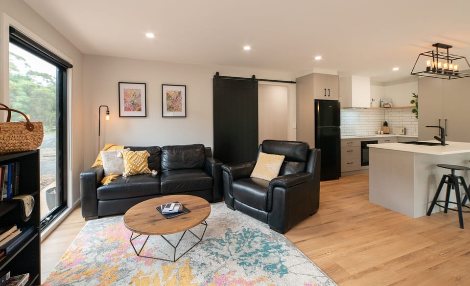 Relax in the light-filled living area, where the sofas offer cosy seating to kick back with a movie