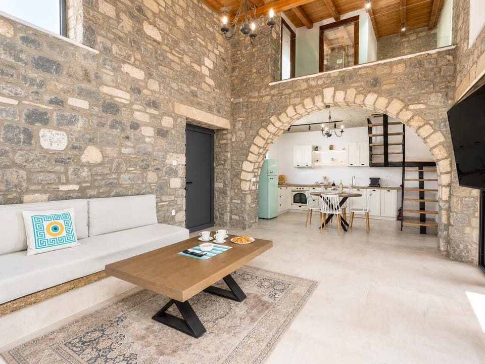 Open-plan living room with sofa, dining area, kitchen, A/C, WiFi internet, and satellite TV
