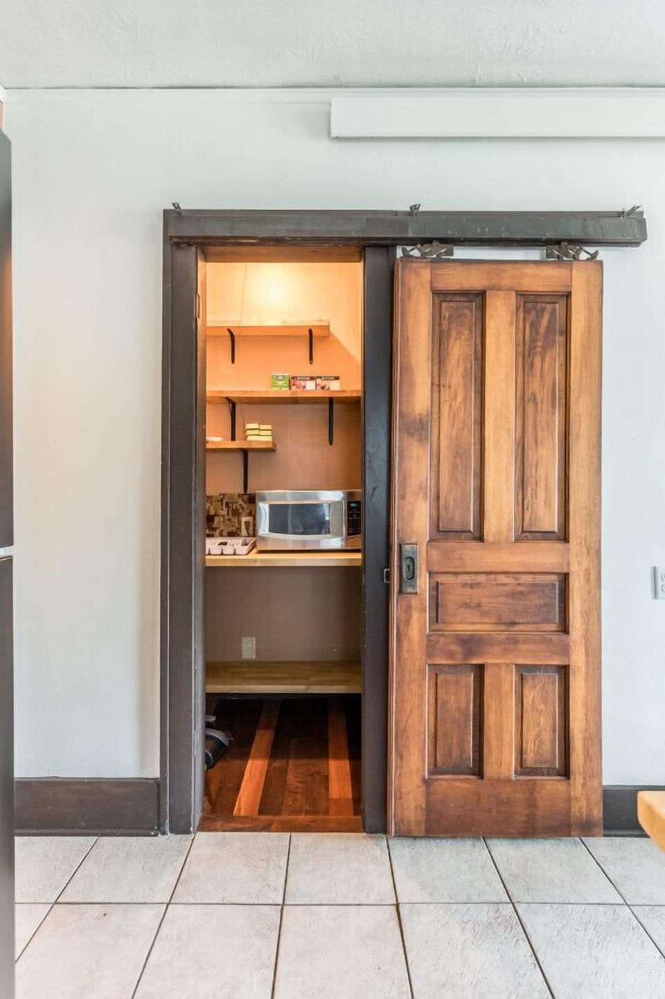 Discover a hidden gem in our unique hidden pantry with a stylish barn door. Experience the charm and convenience of a well-organized space