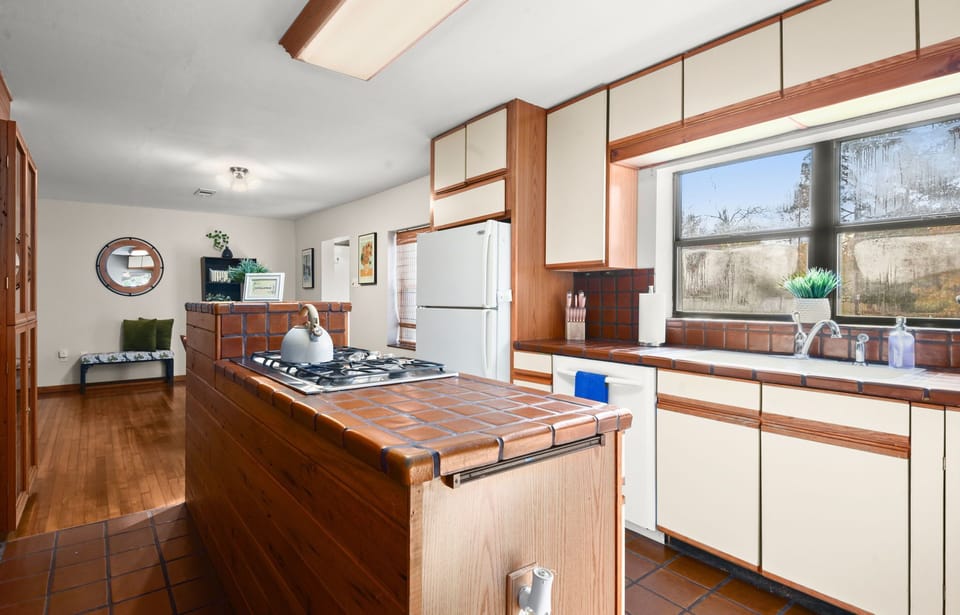 Delight in the culinary possibilities of a spacious kitchen, fully equipped with essentials, inviting you to enjoy and have fun while preparing meals in the heart of this welcoming home.