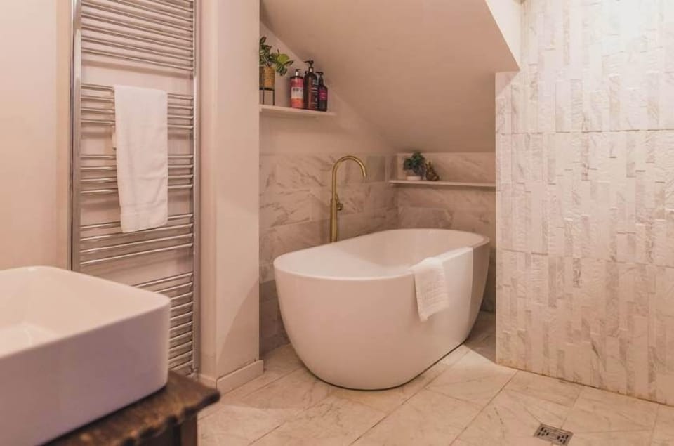 A luxurious white bathroom with a freestanding tub, and modern finishes.